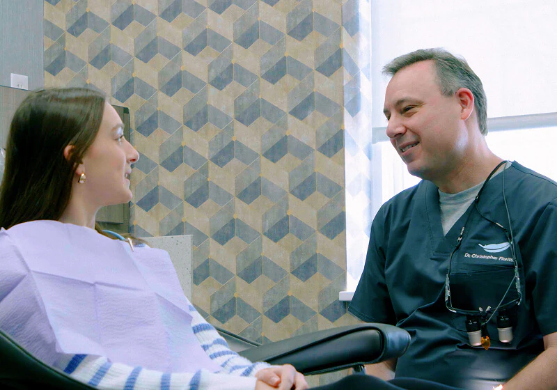 The dentist from Frioritto speaking with a female patient about clear aligner options in the exam chair in OH.