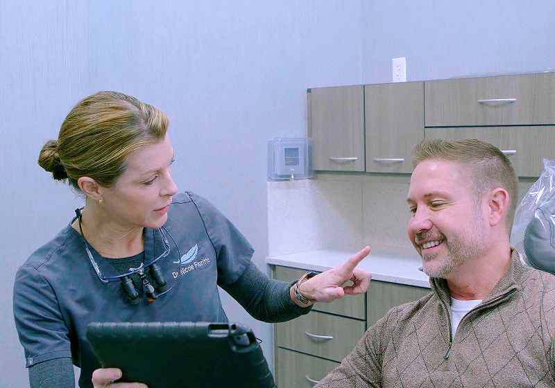 A male patient smiling at a female staff member in the exam room while discussing Restorative Dentistry in Mentor and Concord, OH